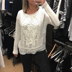 White, detailed sweater.